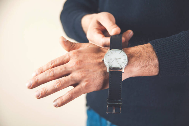 灰色の背景に男の手の時計 - 写真・画像