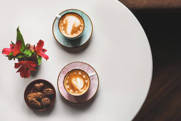 Чашки кофе с искусством латте на столе в кафе - Фото, изображение