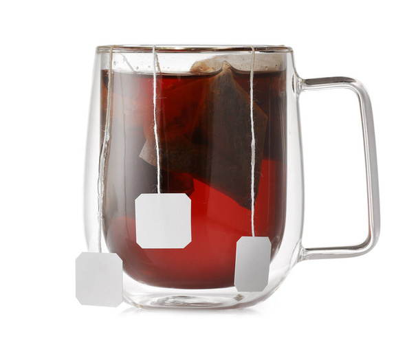 Чашка горячего ароматного черного чая на белом фоне - Фото, изображение