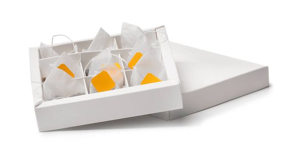 Коробка с пакетиками чая на белом фоне - Фото, изображение