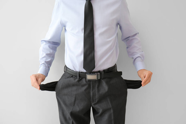 Homme d'affaires avec poches vides sur fond blanc. Concept de faillite - Photo, image