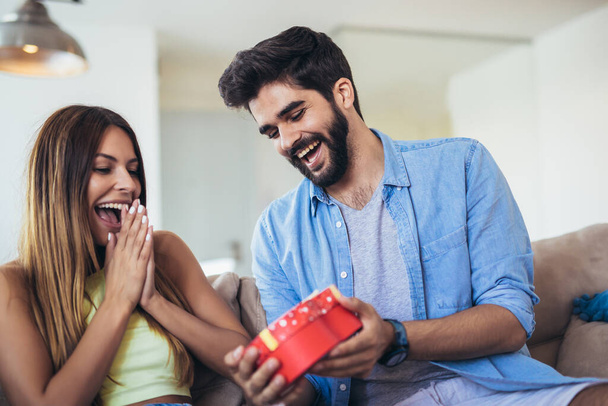 Man giving a surprise gift to woman at home - Photo, Image