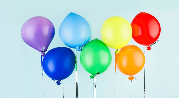 De petites boules gonflables de couleurs arc-en-ciel pendent sur un ruban. Contenu de vacances. Concept d'art - Photo, image