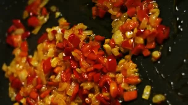 Il peperone rosso fresco tritato, la cipolla e l'aglio vengono fritti su una padella. Preparare il ripieno per qesadillas. Processo di fabbricazione delle quesadillas - Filmati, video