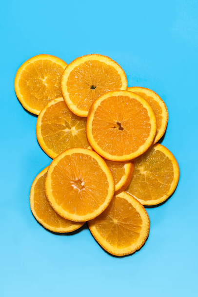 Πολλές φέτες πορτοκαλιού πάνω σε μπλε φόντο - Φωτογραφία, εικόνα