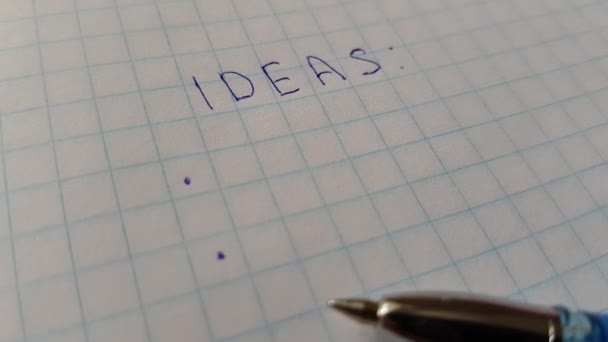 słowa pomysły na papier w kratkę i niebieski długopis. - Materiał filmowy, wideo