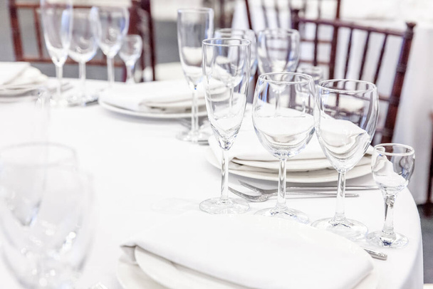 Hieno pöytä päivälliselle lautasliina lasit ravintolassa, ylellinen sisustus tausta. Häät tyylikäs juhla koristelu ja kohteita ruokaa järjestetty catering palvelun valkoinen pöytäliina pöytä - Valokuva, kuva