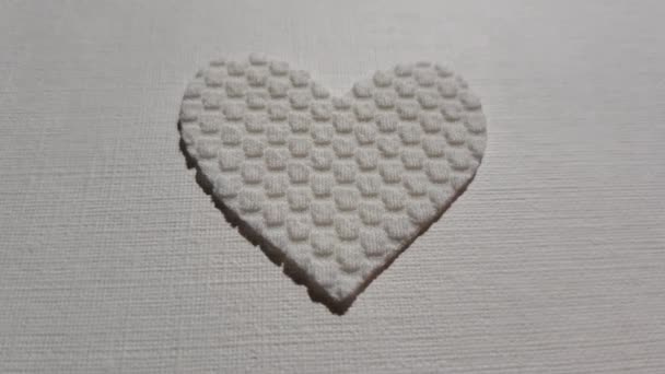 Симпатичное белое сердце из текстурированного материала биения сердца на столе - Кадры, видео