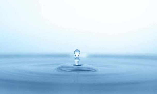 kapka vody stříkance ve skleněné modré - Fotografie, Obrázek
