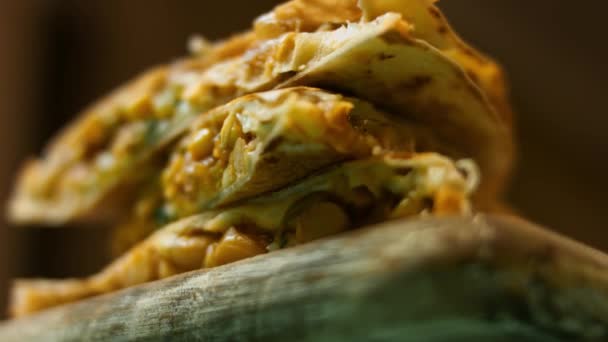 Świeżo usmażona gorąca quesadilla warzywna na drewnianej desce do krojenia. Proces robienia meksykańskich quesadilli. Widok makro - Materiał filmowy, wideo