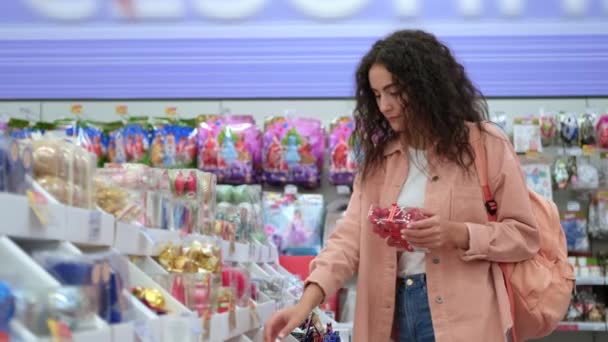 joven morena mujer está comprando decoraciones de Navidad en el supermercado - Metraje, vídeo