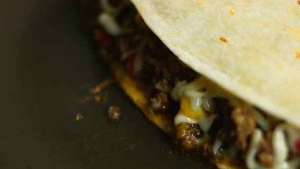 Frying a freshly wraped beef quesadilla on a frying pan. Process of making mexican quesadillas. Macro view - Footage, Video