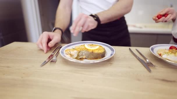 Pareja cocinando filete de salmón juntos en casa - Imágenes, Vídeo