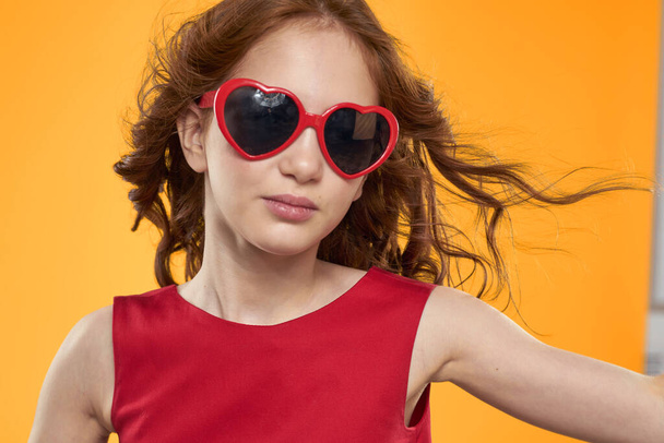 Chica en gafas negras vestido rojo infantil divertido fondo amarillo - Foto, Imagen