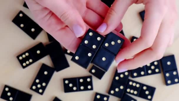 Hraní domino na dřevěném stole. Ženy ruku s dominem. Koncept zábavních her. Selektivní soustředění. Stolní hra dívka hrát - Záběry, video