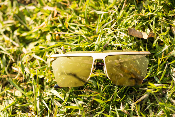 Futurystyczny Zróżnicowany model okularów przeciwsłonecznych ze złotymi soczewkami kręci się na zewnątrz natury w słoneczny dzień zbliżenia. Skupienie selektywne - Zdjęcie, obraz