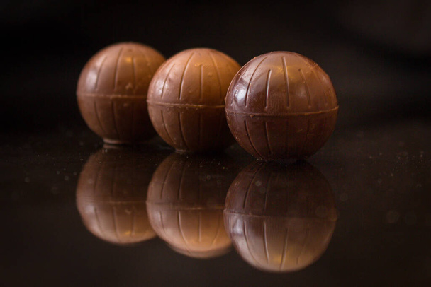 widok z bliska słodkie pyszne cukierki czekoladowe na czarnym tle - Zdjęcie, obraz