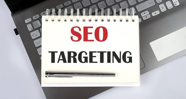 SEO TARGETING - Top view notebook writing on laptop - Photo, Image