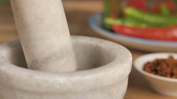 Традиционная каменная миномётная смесь для приготовления острого Масалы. Шлифовальный миномет с красным и зеленым чили и начинка Масала для маринования в размытом фоне - Кадры, видео