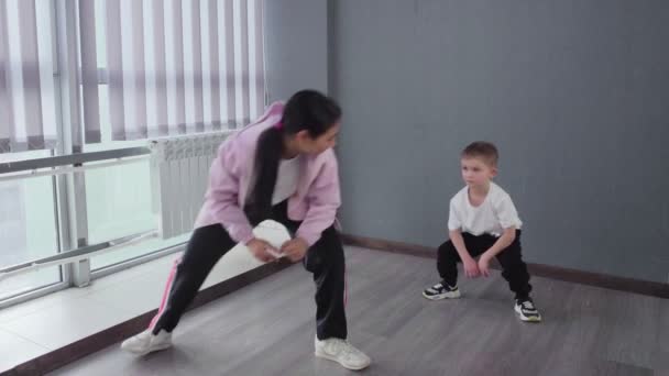 Kleiner Junge macht Übung zum Aufwärmen, um sich auf Breakdance-Hip-Hop-Tanzstunde vorzubereiten - Filmmaterial, Video