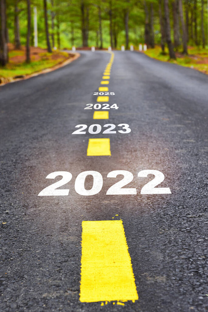 Nuevo año de 2022 2023 2024 y 2025 en la superficie de la carretera de asfalto con líneas de marcado. Feliz año nuevo concepto y mantener la idea en movimiento - Foto, imagen