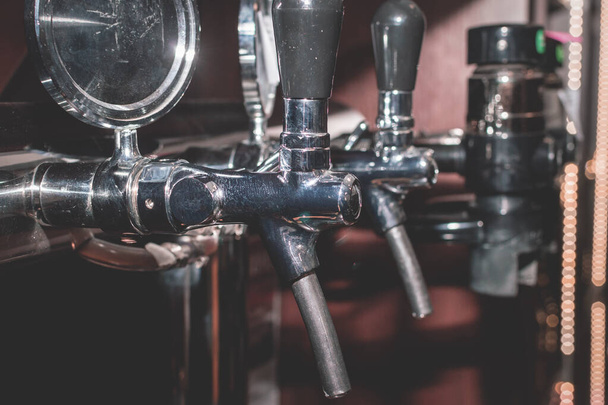 Row of Beer Taps in Pub. A side shot of a bar, pub installation and the draught beer pump handles. - Fotó, kép