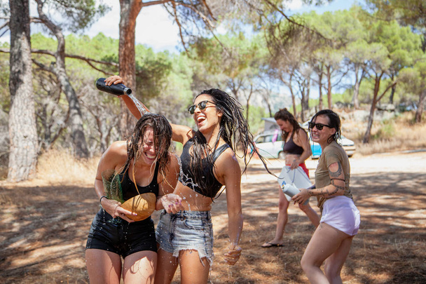 San martin de Valdeiglesias, Madrid, Spagna. Gruppo di donne che giocano con l'acqua per rinfrescarsi in estate vicino a una fontana. - Foto, immagini
