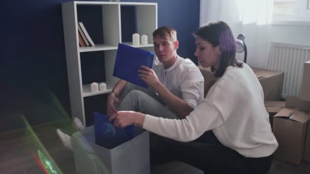 Happy couple prepare to moving out relocation, family sitting on floor in living room and checks their documents - Footage, Video