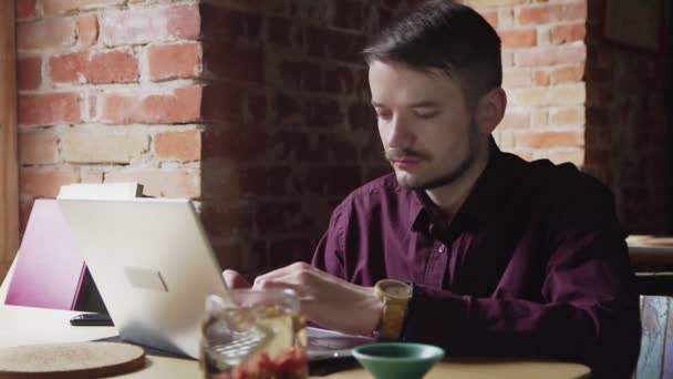 Ο συγγραφέας αντρικών βιβλίων δουλεύει στο καφέ. Νεαρός τύπος στο σημειωματάριο στο καφέ τσάι - Πλάνα, βίντεο