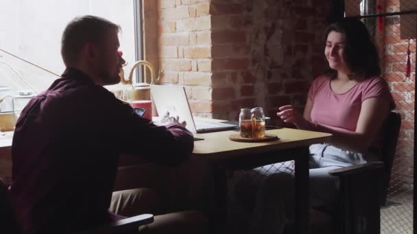 Jovem e mulher sentam-se no café chinês e discutem ideias de negócios de startup - Filmagem, Vídeo