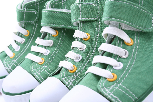 twee paren van groene sneakers voor kinderen close-ups - Foto, afbeelding