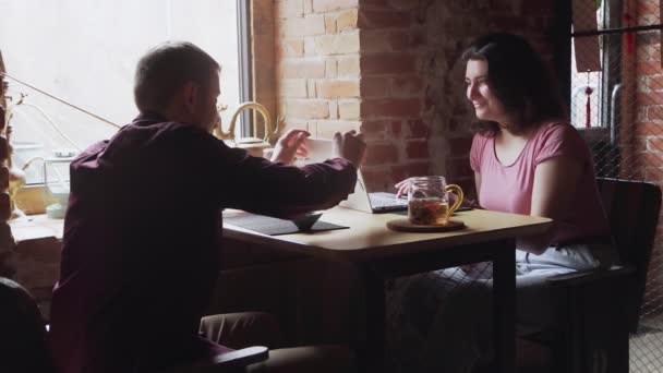 Usmívající se pár si užívá romantické setkání v kavárně a mluví spolu o čase v čínské čajové kavárně. Muž zavírá ženy notebook - Záběry, video