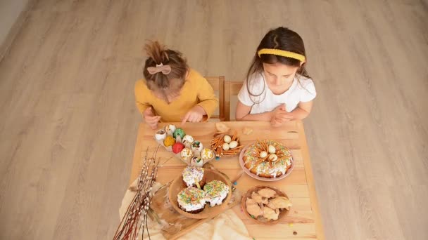 crianças na mesa de Páscoa comer bolos de Páscoa - Filmagem, Vídeo