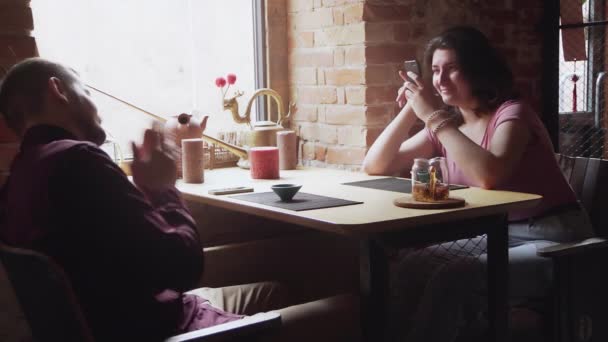 Una donna fa una foto al suo ragazzo. Incontri coppia rilassante insieme nel caffè tè cinese - Filmati, video