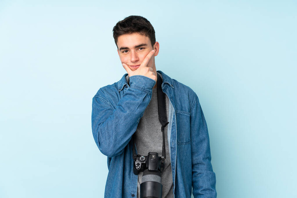 nastoletni fotograf człowiek odizolowany na niebieskim tle myśląc pomysł - Zdjęcie, obraz