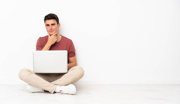 Adolescente seduto sul volantino con il suo computer portatile pensando - Foto, immagini