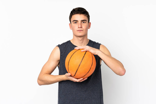 Handsome young basketball player man over isolated wall playing basketball - Zdjęcie, obraz