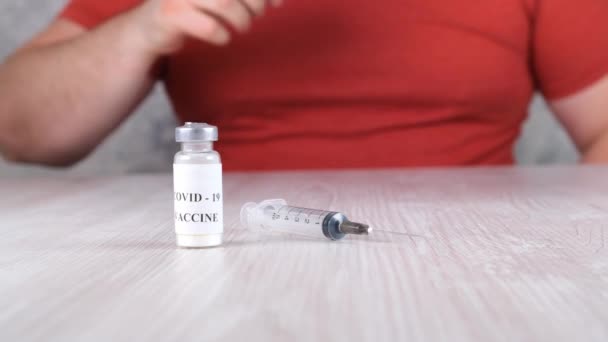 Vials with a vaccine against coronavirus, influenza and dangerous diseases and a syringe and male hands. Corona virus, flu, injections, shots and clinical trials treatment concept during pandemic - Footage, Video