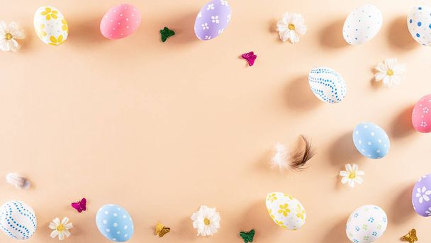 Buona Pasqua! Colorato di uova di Pasqua in con fiore su sfondo pastello. Saluti e regali per il giorno di Pasqua celebrano il tempo. Posa piatta, vista dall'alto. - Foto, immagini