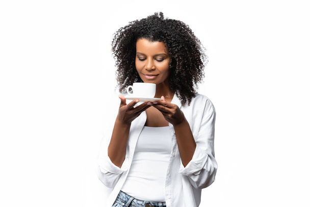 Afroamerikanerin riecht Tasse Kaffee isoliert auf weiß  - Foto, Bild
