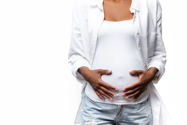 Καλλιεργημένη άποψη της εγκύου Αφροαμερικανή γυναίκα απομονωμένη σε λευκό  - Φωτογραφία, εικόνα