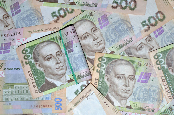Украинские деньги (грн). Стопка 500 гривен на 500 гривен на заднем плане. Концепция бизнеса и финансов - Фото, изображение