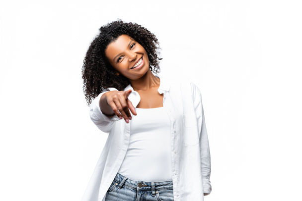 Χαμογελώντας αφροαμερικανή γυναίκα που δείχνει με το δάχτυλο την κάμερα απομονωμένη στο λευκό - Φωτογραφία, εικόνα