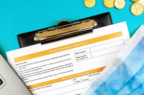 Travel insurance claim form and application close up, new normal travel concept with medical mask - Φωτογραφία, εικόνα