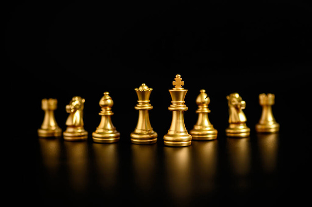 Pezzi di scacchi d'oro su sfondo nero, concetto di strategia aziendale. Concetto di lavoro di squadra aziendale. - Foto, immagini