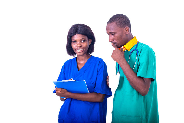 врач-мужчина обсуждает медицинский отчет на планшете с медсестрой в больнице. - Фото, изображение