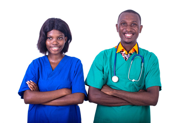 мужчина-врач с медсестрой, стоящей в униформе, скрещивая руки в больнице и улыбаясь в камеру. - Фото, изображение