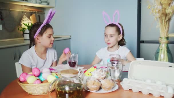 Irmãzinhas engraçadas colocar ovos coloridos na cesta no dia de Páscoa - Filmagem, Vídeo