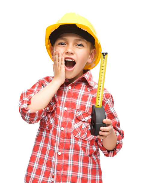 Niño como trabajador de la construcción con cinta métrica
 - Foto, imagen