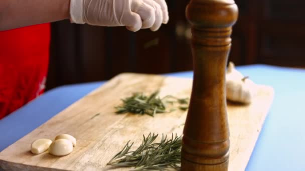 女性の手はローズマリーの新鮮な小枝から葉を削除します。完璧なオーブンローストポテトを調理するプロセス - 映像、動画